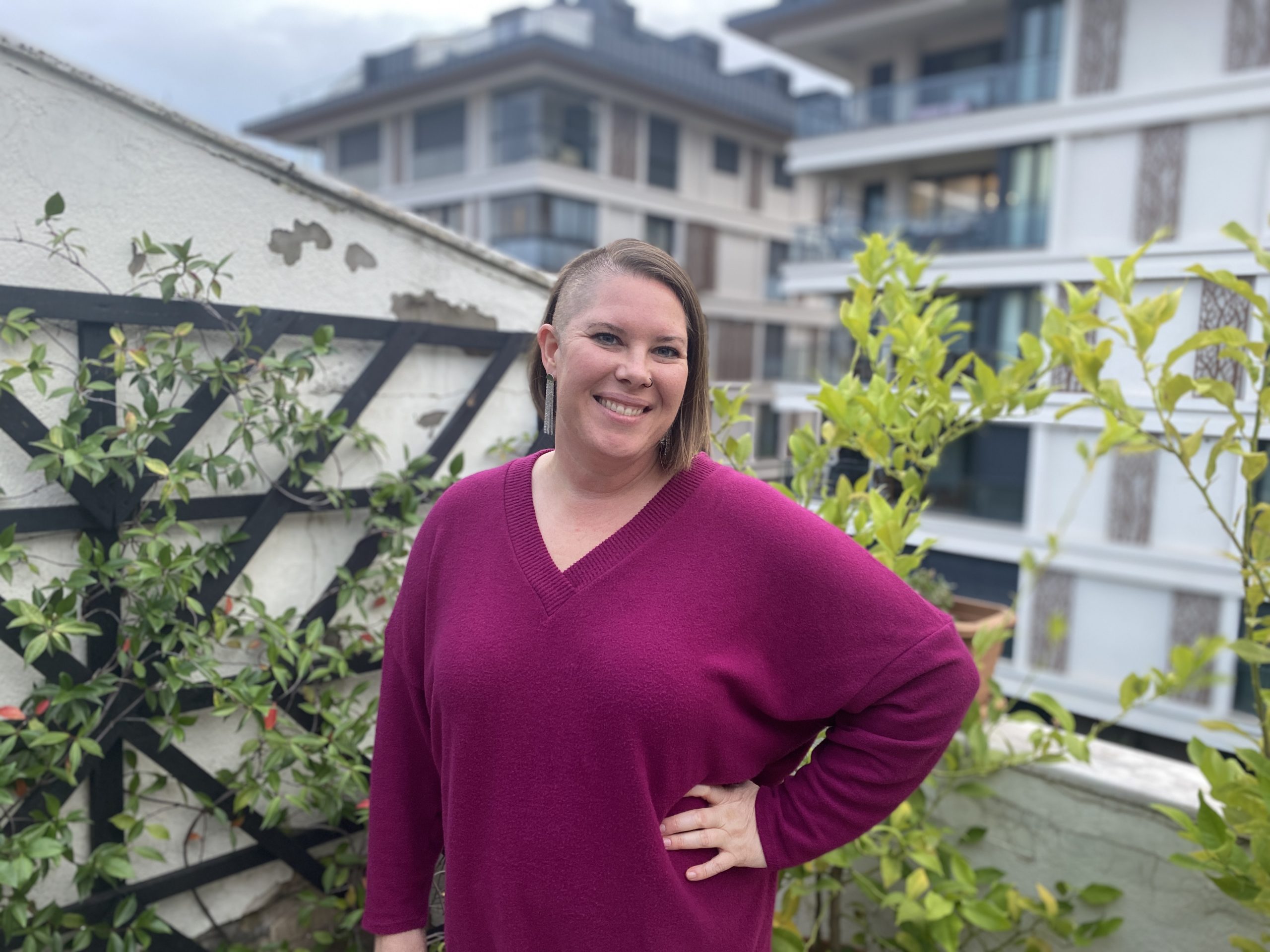 Kimberly on a rooftop balcony with a lattice in the background